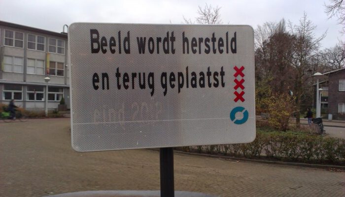 Bord in Amsterdam met de tekst: Beeld wordt hersteld en teruggeplaatst.