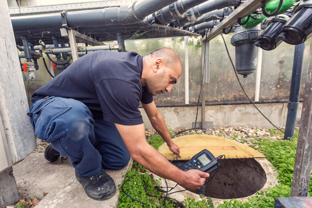Een medewerker checkt de waterkwaliteit met speciale apparatuur.