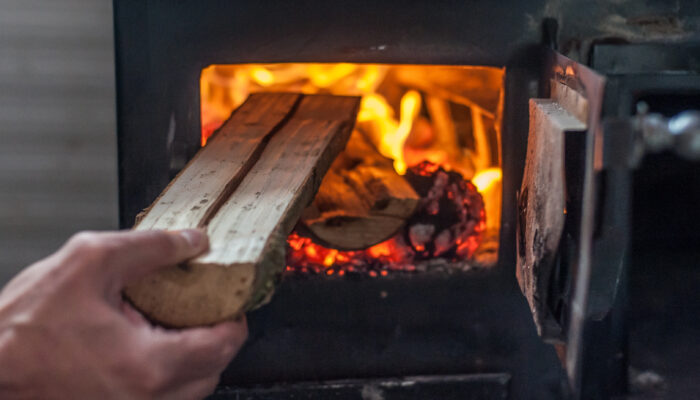Houtblok wordt in haardvuur gegooid