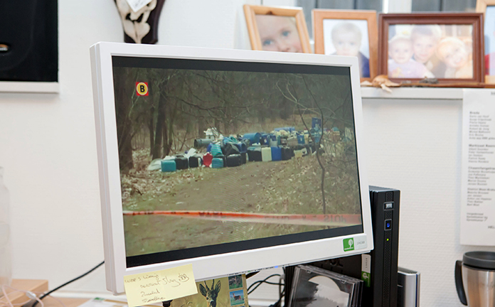 Op een computerscherm is een foto te zien van gedumpt drugsafval.