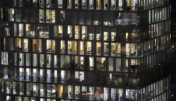 Afbeelding van kantoorpand waar overal het licht nog brandt.