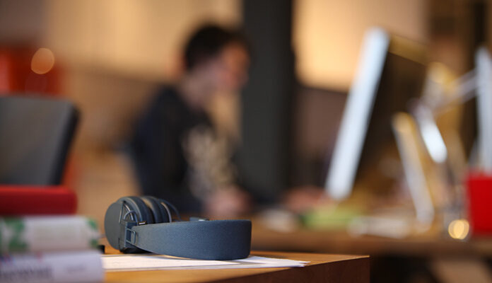 Onherkenbare jongen zit achter laptop.