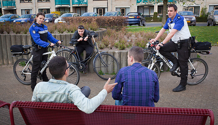 Boa's spreken jongeren aan die op een bankje zitten.