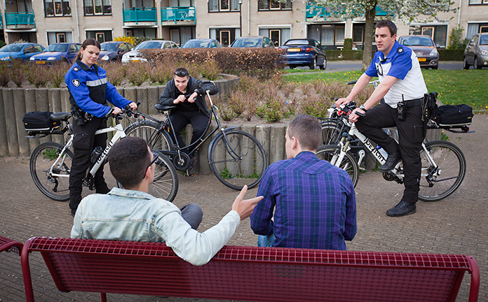 Boa's spreken jongeren aan die op een bankje zitten.