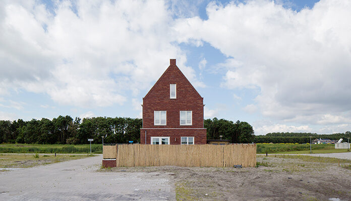 Huis op vlakte met groot hek eromheen