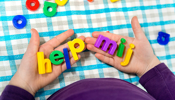 2 handen houden letters vast die samen de tekst 'Help mij' vormen.