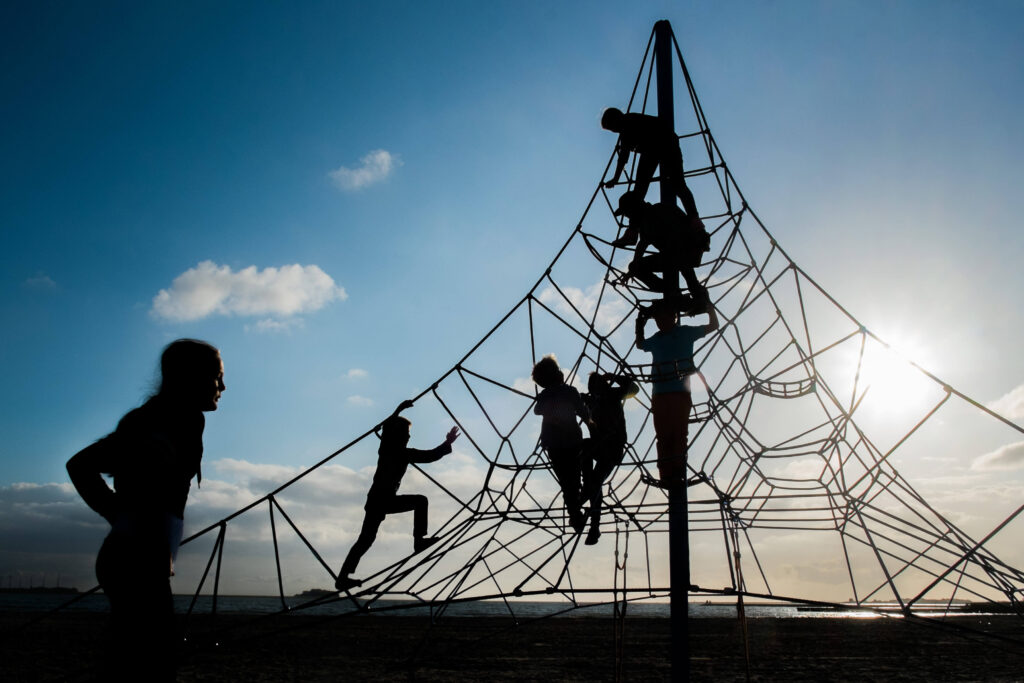 Kinderen spelen buiten in klimpiramide van touw