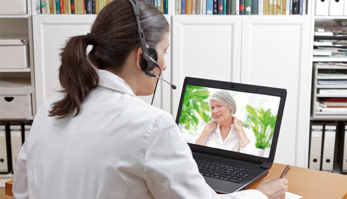 Arts via laptop in contact met patiënte