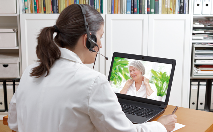 Arts via laptop in contact met patiënte