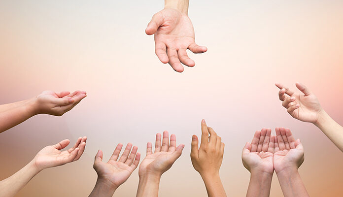 Meerdere handen reiken naar 1 hand