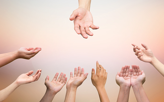 Meerdere handen reiken naar 1 hand