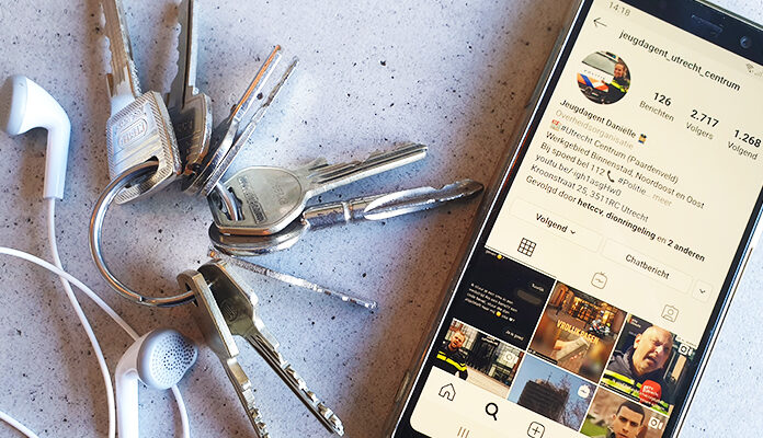 Telefoon met daarop de instagram-pagina van jeugdagent Daniëlle naast een sleutelbos