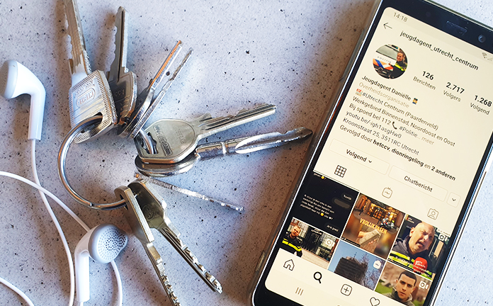 Telefoon met daarop de instagram-pagina van jeugdagent Daniëlle naast een sleutelbos