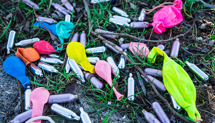 Lachgas ampullen en ballonnen in de natuur