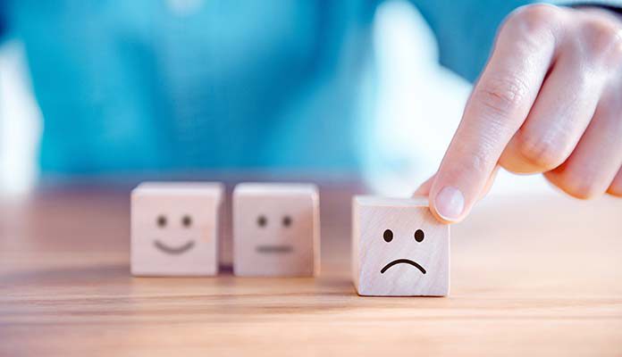 Blokjes met gezichtjes erop. Het verdrietige gezicht wordt naar voren geschoven.