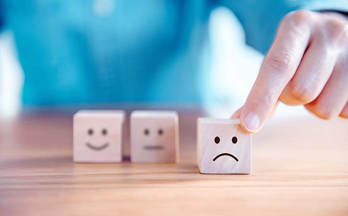 Blokjes met gezichtjes erop. Het verdrietige gezicht wordt naar voren geschoven.