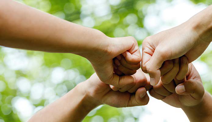 Vier vuisten geven elkaar een boks