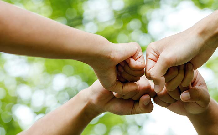 Vier vuisten geven elkaar een boks