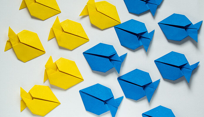 Papieren visjes waarbij de gele visjes naar rechts zwemmen en de blauwe visjes naar links