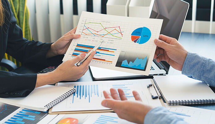 Afbeelding waarbij twee personen de cijfers van een organisatie bespreken