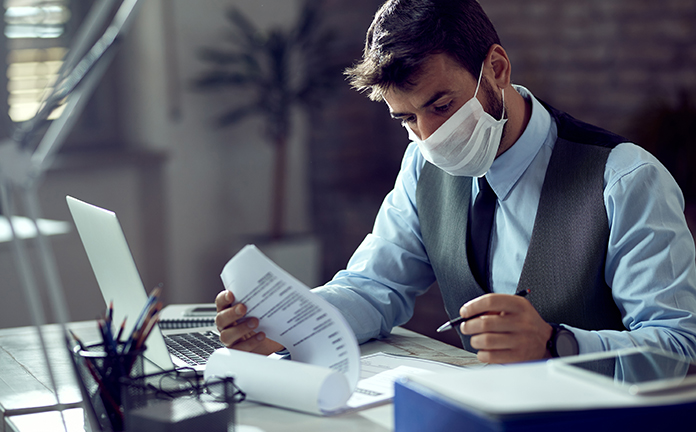 Man controleert document met mondkapje op