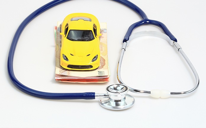 Speelgoedauto staat op briefgeld met daaromheen een stethoscoop