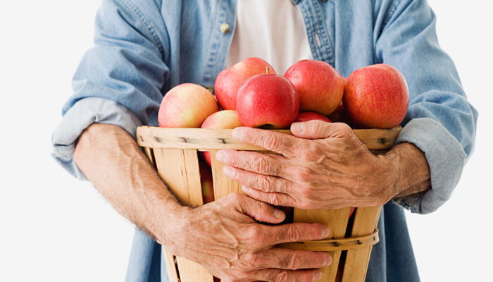 Man houdt mand met appels in handen.