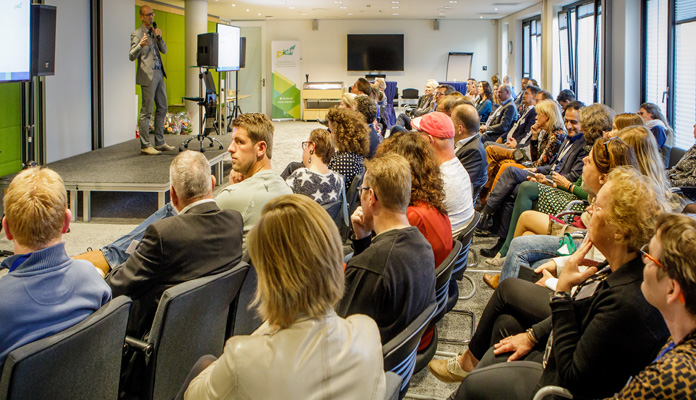 Geïnteresseerden luisteren naar genomineerde Verkiezingen Handhaving en Toezicht