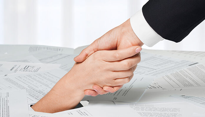 Hand wordt vastgepakt uit brei van papier