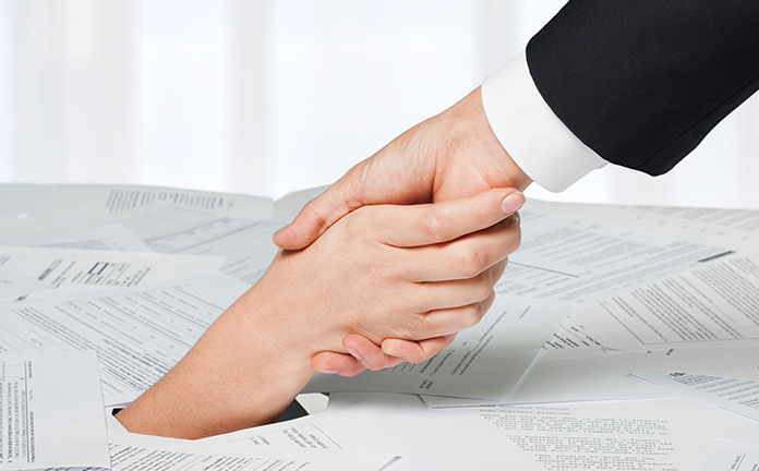 Hand wordt vastgepakt uit brei van papier