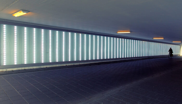 Tunnel met verlichting waar fietser doorheen fietst