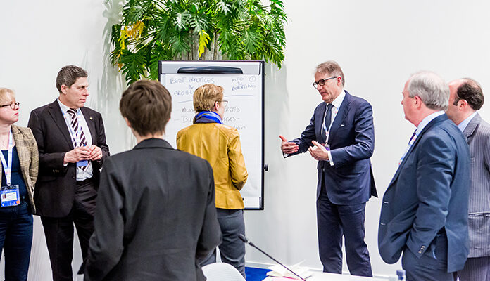 Een overleg voor een white board met mensen in pak