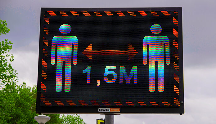 Elektronisch bord waarop staat dat er 1,5 meter afstand gehouden moet worden