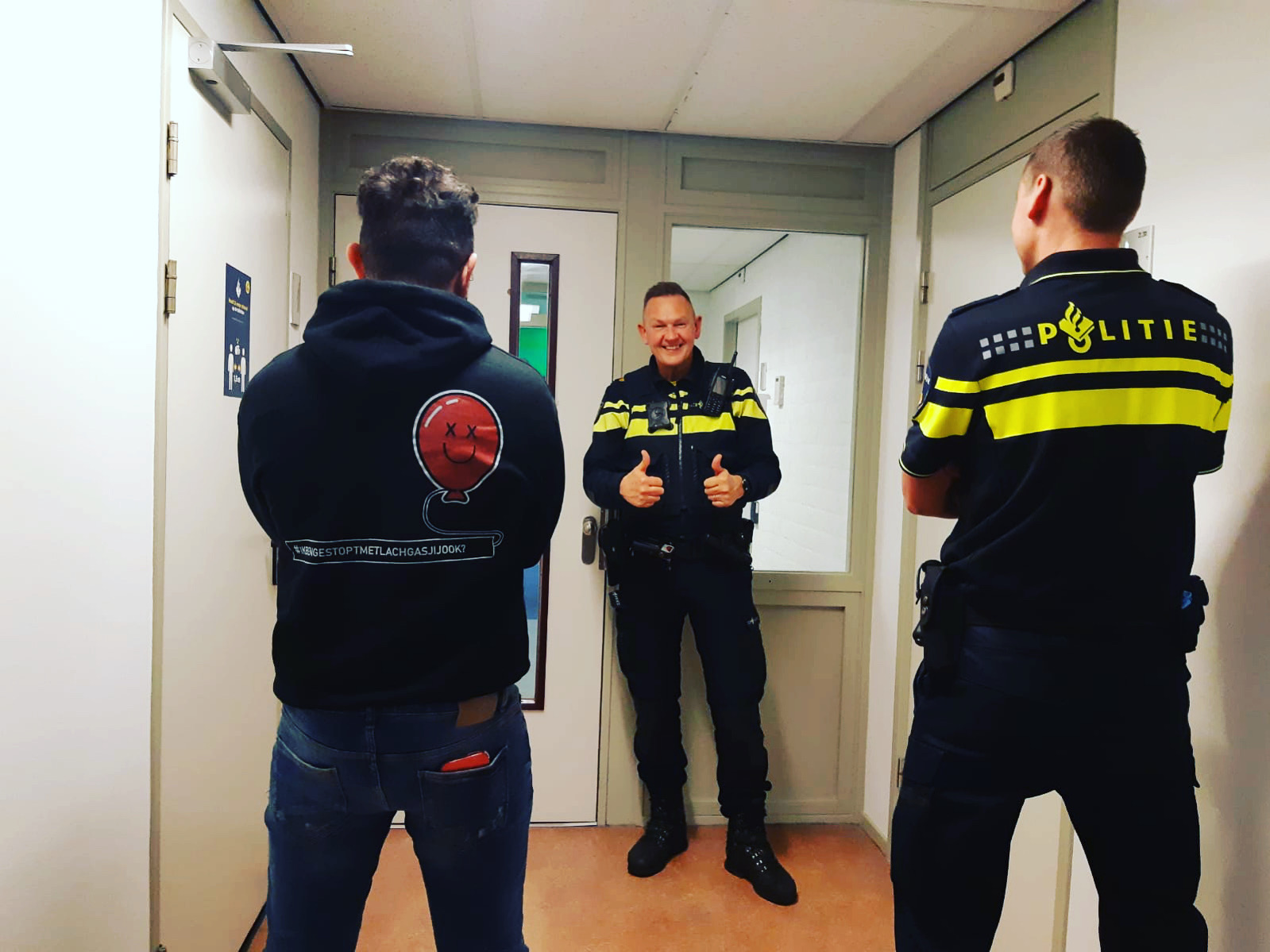Twee politie-agenten staan met ex-lachgaskoning