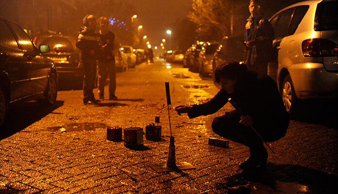 Een jongen steekt een vuurpijl af.