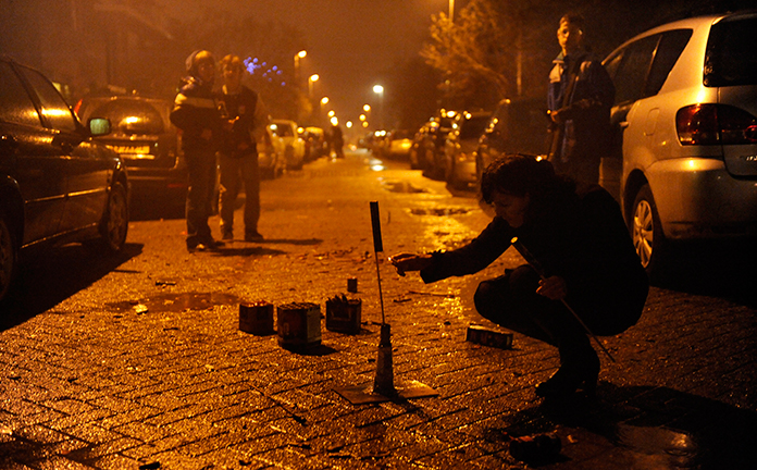 Een jongen steekt een vuurpijl af.