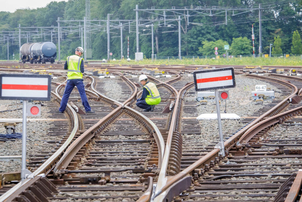 Twee toezichthouders controleren het spoor