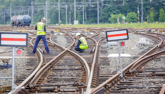 Twee toezichthouders controleren het spoor