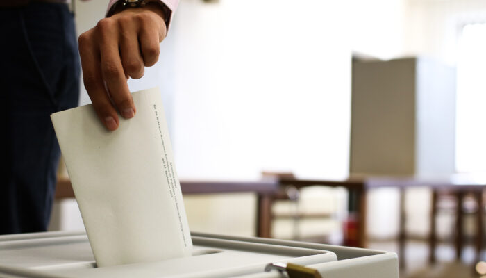 Afbeelding van iemand die stembiljet in stembus doet