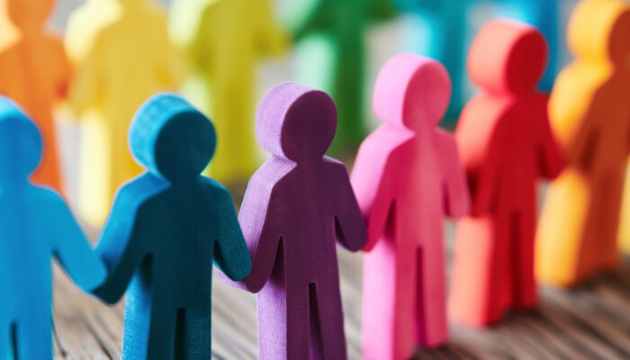 Afbeelding van gekleurde poppetjes die elkaars handen vasthouden