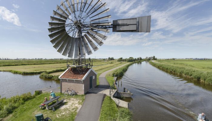 Foto van waterrijk gebied met windmolen