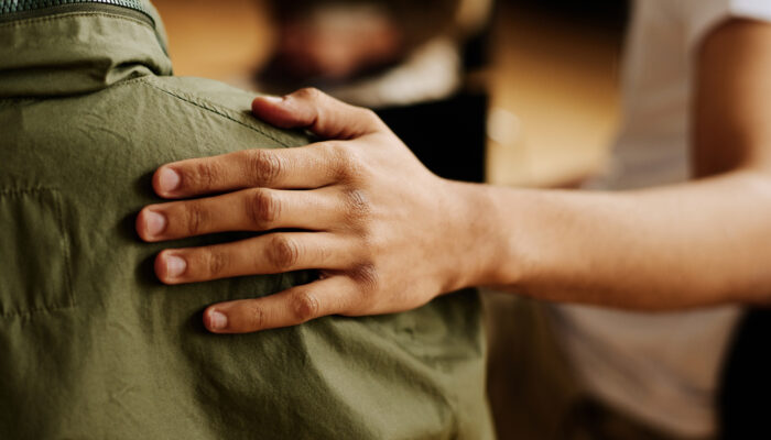 Hand op schouder van verdrietig iemand