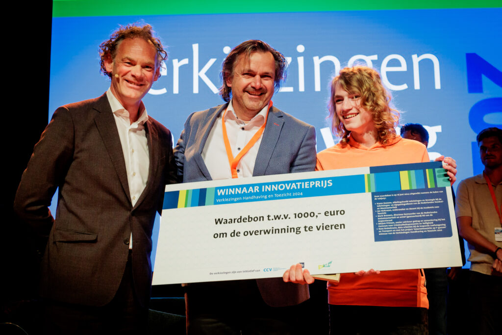 Uitreiking Innovatieprijs Verkiezingen Handhaving en Toezicht 2024 - Juryvoorzitter Mark Bressers overhandigt prijs aan Wilfred en Ferrand Mijnheer
