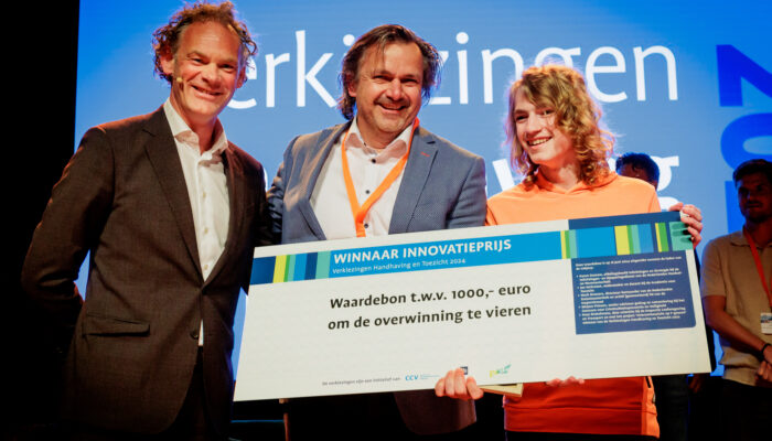 Uitreiking Innovatieprijs Verkiezingen Handhaving en Toezicht 2024 - Juryvoorzitter Mark Bressers overhandigt prijs aan Wilfred en Ferrand Mijnheer