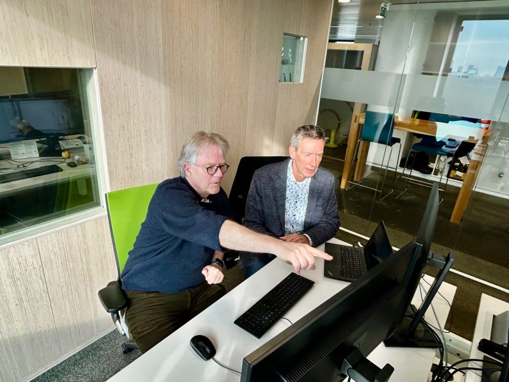 Jon Pronk en Rob Hosman zitten achter een computer