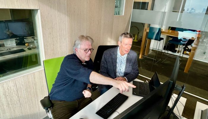 Jon Pronk en Rob Hosman zitten achter een computer